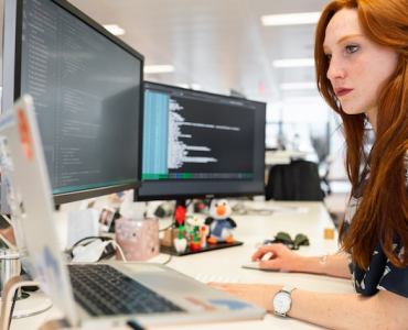 Female software engineer codes at computer