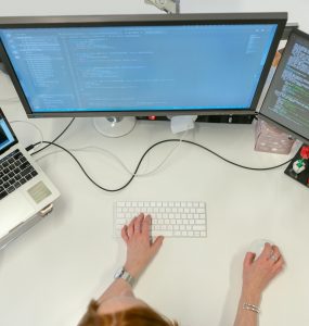 Person Coding on Laptop and Pc
