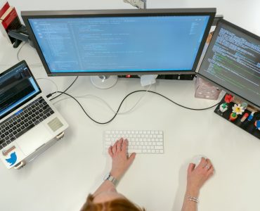 Person Coding on Laptop and Pc