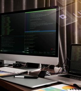 Monitor and a Laptop Against the Backdrop of Code