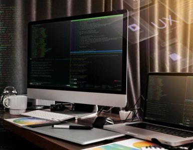 Monitor and a Laptop Against the Backdrop of Code