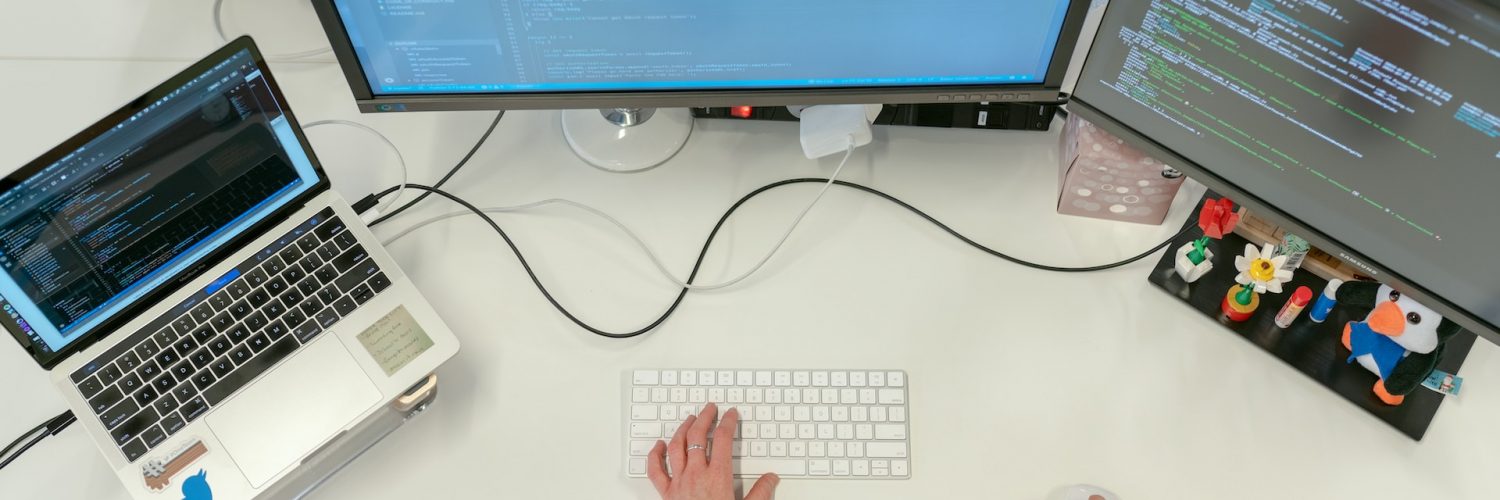 Person Coding on Laptop and Pc