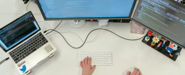 Person Coding on Laptop and Pc