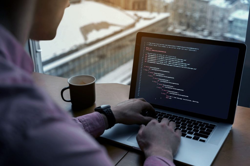 Man working on laptop with code