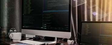 Monitor and a Laptop Against the Backdrop of Code